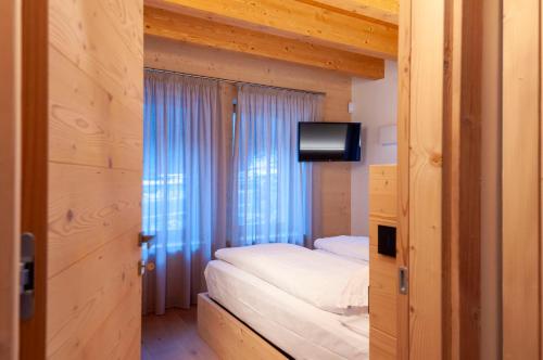 a bedroom with a bed and a television in it at Antico Borgo Palue in Sottoguda
