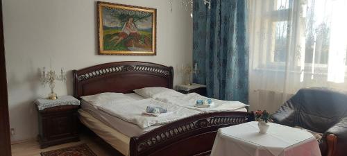 オストラヴァにあるHotel Garniのベッドルーム1室(ベッド1台、テーブル、窓付)