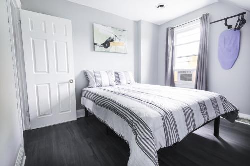 a white bedroom with a bed and a window at Comfy Micro Apartment 1BR 1 Bath close to the falls in Niagara Falls