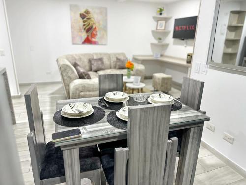 comedor con mesa, sillas y sofá en Habitación premium sede 3, en Ibagué