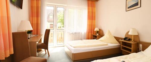 a hotel room with two beds and a window at Hotel zum Alten Wirt in Langenbach