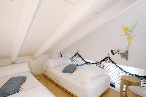 a bedroom with a white bed in a attic at Conversas de Alpendre in Vila Nova de Cacela