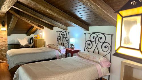 1 dormitorio con 2 camas y ventana en Casa Rural Montes de Trigo, en Jerez de los Caballeros