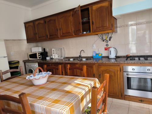 a kitchen with a table with a table cloth on it at Apartamentos Campos 2 in Porto Covo
