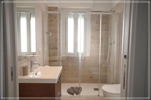 a bathroom with a shower and a toilet and a sink at Medico Romantic House in Monopoli