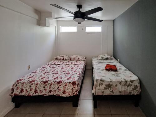 a bedroom with two beds and a ceiling fan at CASA FOTR LOCO in Uvita