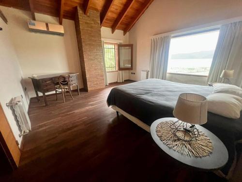 a bedroom with a bed and a table and a desk at CASA VILLA LAGO AZUL CARLOS PAZ in Villa Carlos Paz