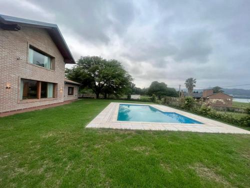 a swimming pool in a yard next to a house at CASA VILLA LAGO AZUL CARLOS PAZ in Villa Carlos Paz