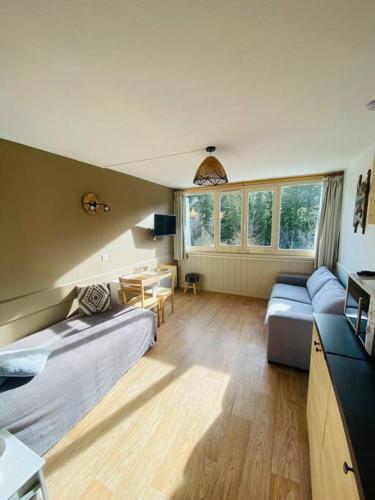 un salon avec un lit et un canapé dans l'établissement Appartement résidence le bec de l’aigle, à Laveissière