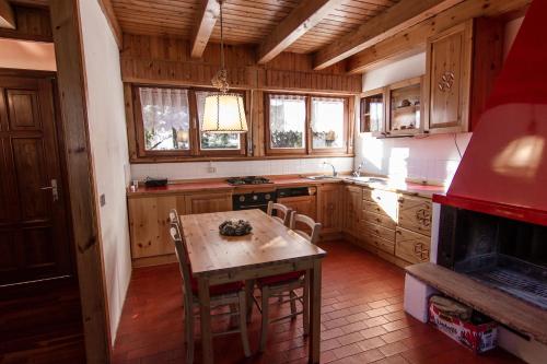 una cucina con armadi in legno, tavolo e piano cottura di App Carolina a Creazzo