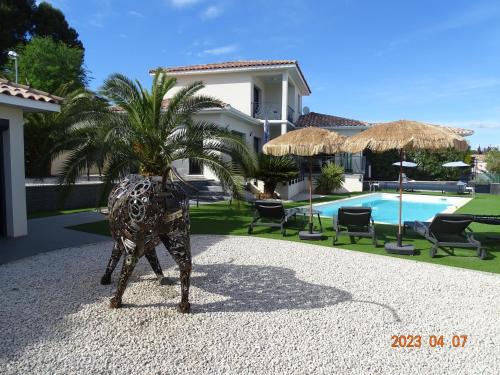 une statue en bronze d'un palmier devant une maison dans l'établissement VILLA ENTRE MER ET MONTAGNE, à Pézenas