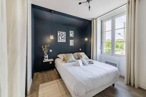 1 dormitorio con 1 cama grande y pared azul en L'Azur chaleureux et cocooning en Segré