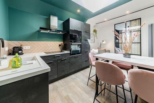 a kitchen with a sink and a table with chairs at L'Azur chaleureux et cocooning in Segré