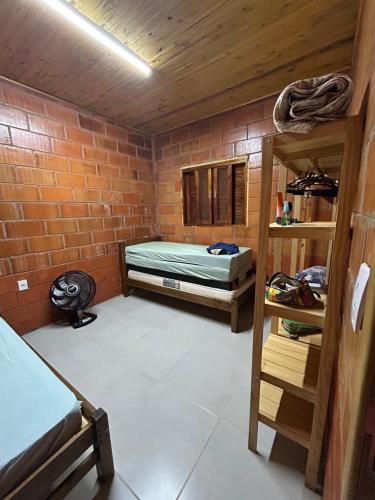 Cette petite chambre dispose d'un lit dans un mur en briques. dans l'établissement Casa condomínio, à Mairinque