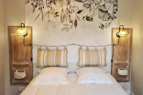 une chambre avec un lit avec deux lampes dessus dans l'établissement Gîte de charme 3 étoiles à proximité de la mer, à Saint-Molf