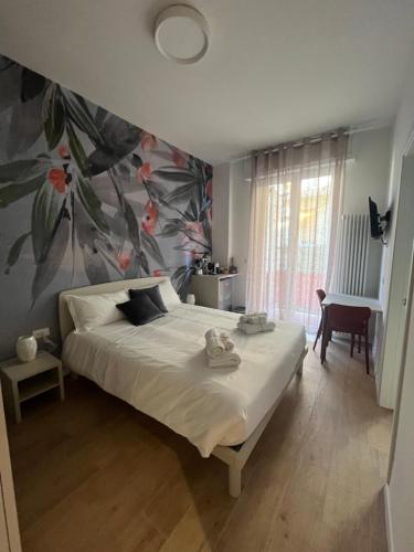 een slaapkamer met een groot bed met bloemenbehang bij CALARI ROOMS - AFFITTACAMERE in Bologna