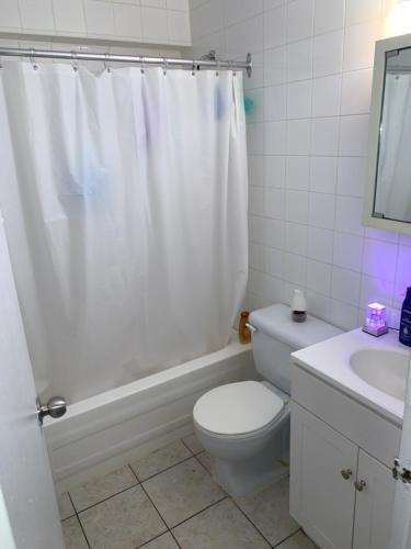 La salle de bains blanche est pourvue de toilettes et d'un lavabo. dans l'établissement Appartement 2 Chambre neuf, à Longueuil