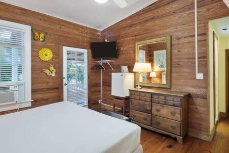 a bedroom with a bed and a mirror and a dresser at Curry House- 3rd Floor, King Bed, & Balcony Room 8 in Key West
