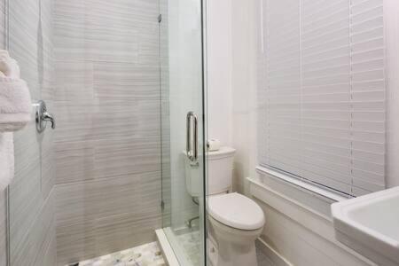 y baño con aseo y ducha acristalada. en Curry House by Brightwild- 3rd Floor, King Bed, & Balcony Room 8, en Key West