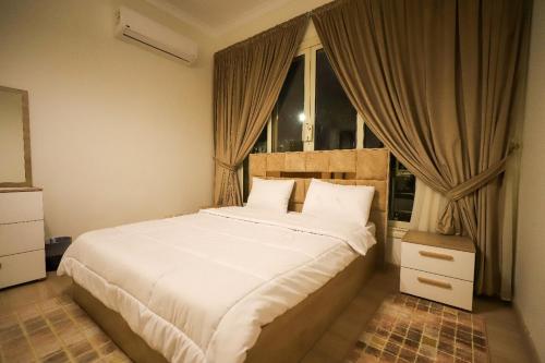 a bedroom with a large white bed with a window at Villa X15-11 Grand Heights in 6th Of October