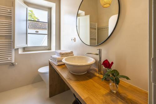 a bathroom with a bowl sink and a mirror at Finca Can Romeu alojamiento rural entre viñedos in Font-Rubí