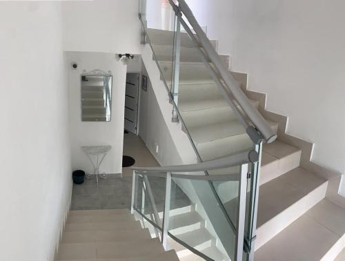a staircase with glass railing in a house at VILLA VINTAGE in Boca Chica