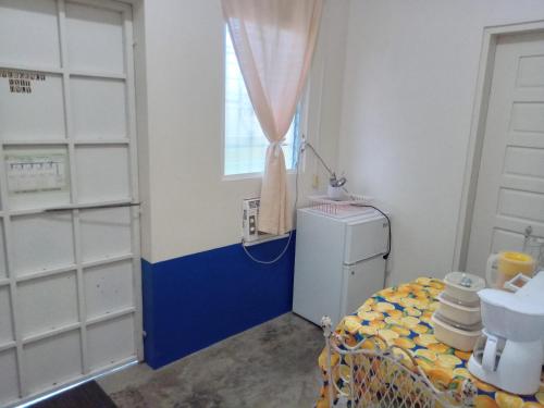 a room with a small refrigerator and a window at Hacienda Tropical Guest House in Belmopan