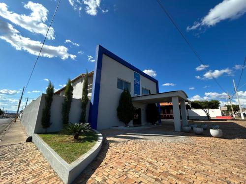 un edificio azul y blanco en una carretera de ladrillo en OSCAR BLUE MATO VERDE, en Mato Verde