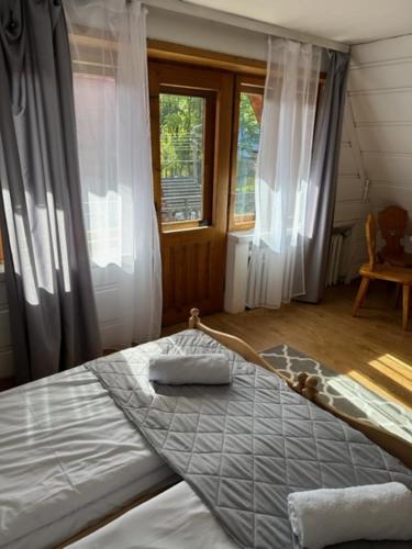 ein Schlafzimmer mit einem großen Bett in einem Zimmer mit Fenstern in der Unterkunft Willa Gronik in Zakopane