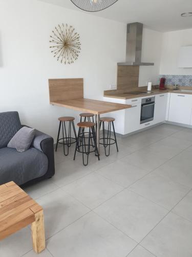 un salon avec un canapé et une cuisine dans l'établissement Appartement à deux pas du port de Bonifacio, à Bonifacio