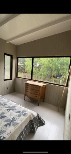 een slaapkamer met een bed en een groot raam bij Nelja Delta Haus in Tigre