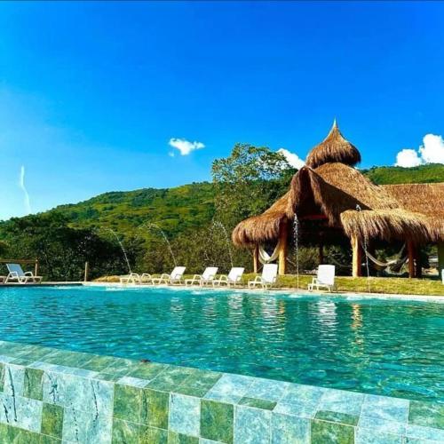 聖赫羅尼莫的住宿－Nalua Glamping y Hotel，一个带椅子和遮阳伞的游泳池