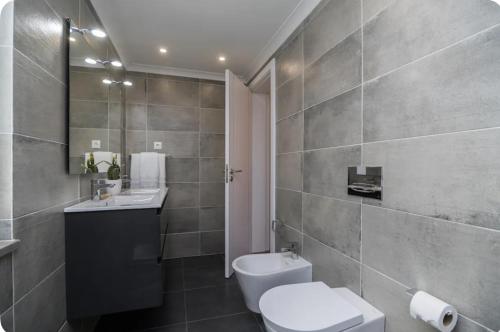 La salle de bains est pourvue de toilettes, d'un lavabo et d'un miroir. dans l'établissement Sintra Design Apartment _ Castelo dos Mouros, à Sintra