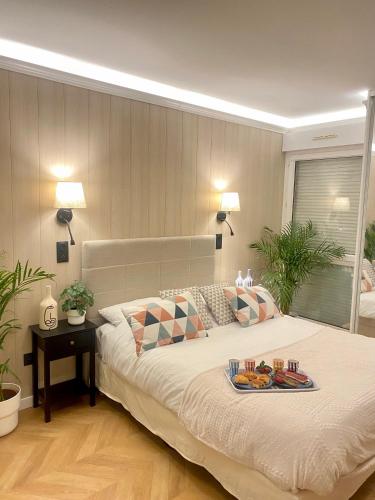 een slaapkamer met een bed met een dienblad met eten erop bij Luxury Appartement with terasse - 15mn from Champs-Elysée in Courbevoie