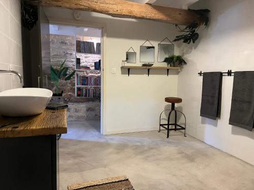 a bathroom with a sink and a counter with a stool at La Maison Culier in Sainte-Alauzie