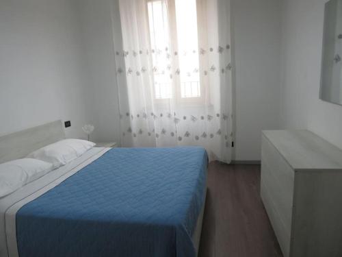 een slaapkamer met een blauw bed en een raam bij La tua casa tra Milano e Como in Caronno Pertusella