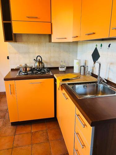 cocina con armarios de color naranja y fregadero en Castelvecchio 172, en Sarnano