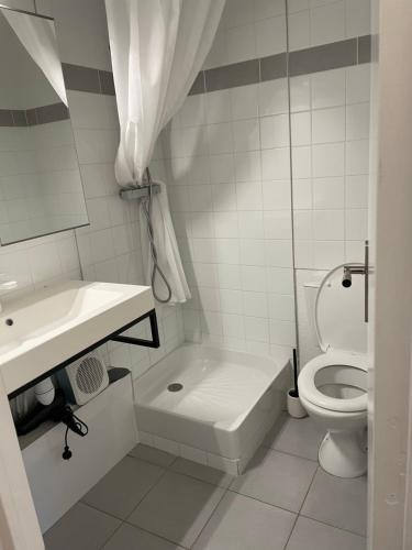 a white bathroom with a toilet and a sink at Studio cabine barcares in Le Barcarès