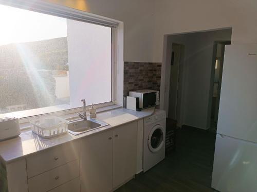 a kitchen with a sink and a washing machine at Sweet Home Nikorenia 2 in Krotiri