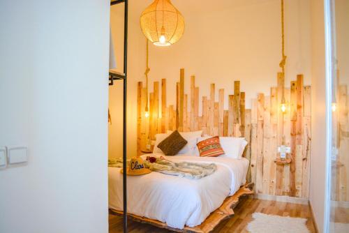 una camera con letto e testiera in legno di MAMA,3 min à la plage10 min à la médina a Essaouira