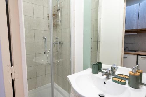 La salle de bains est pourvue d'un lavabo et d'une douche. dans l'établissement The Nice Place proche Paris et Disney, à Neuilly-sur-Marne