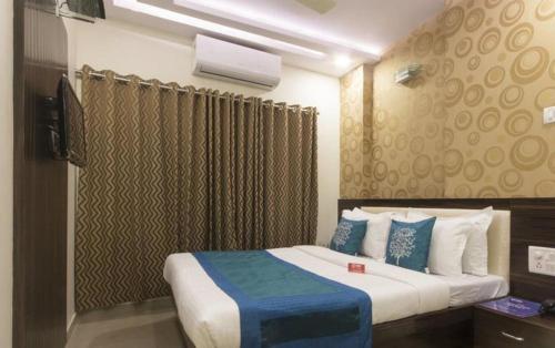 a bedroom with a large bed with blue and white at New Accore Inn Plus By Glitz Hotels in Mumbai
