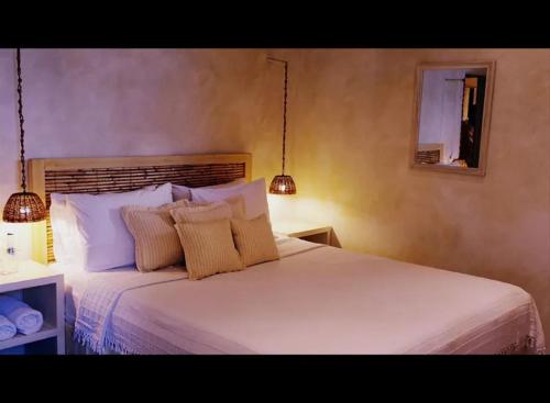 1 dormitorio con 1 cama blanca grande y 2 almohadas en La Maison Kalogera, en Mykonos ciudad