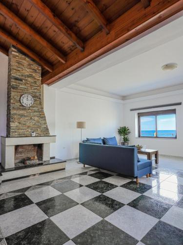 a living room with a blue couch and a fireplace at Angels beach house in Rhodes Town