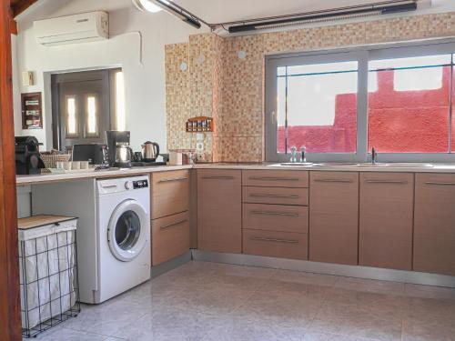 a kitchen with a sink and a washing machine at Angels beach house in Rhodes Town
