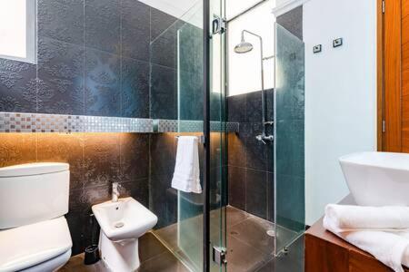 Un baño con inodoro y ducha de cristal. en NEW Amsterdam St Condo Parque Mexico 5-min Walk, en Ciudad de México