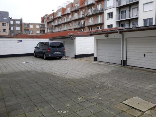 uma carrinha estacionada num parque de estacionamento ao lado de duas garagens em Apartment Testerep in Westende-Bad 150 m van het strand met garage voor 5 personen em Middelkerke