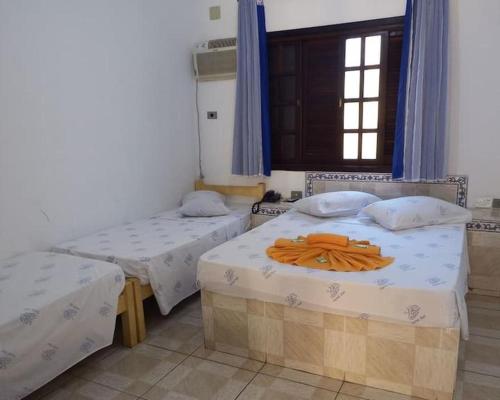 a room with two beds and a window at Hotel Mar in Caraguatatuba