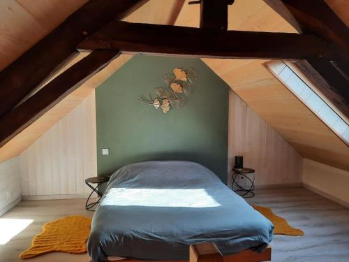 ein Schlafzimmer mit einem Bett im Dachgeschoss in der Unterkunft Gite avec spa sous les étoiles in Erbrée