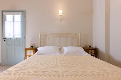 a bedroom with a large bed with white sheets at Monachofolitses in Kimolos